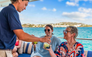 charter crew providing guests with a drink for an all-inclusive yacht vacation